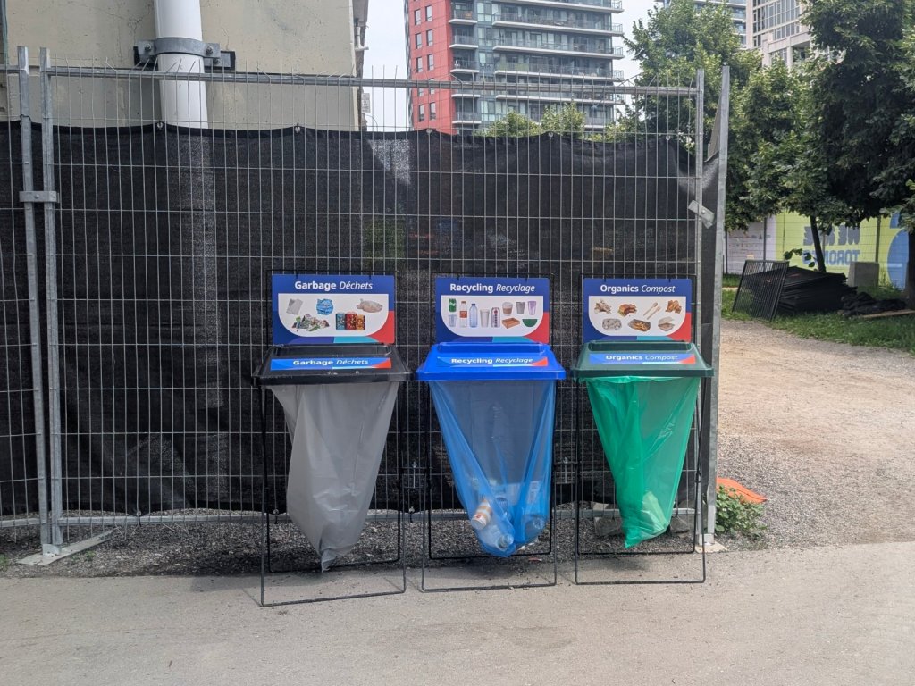 Event-branded garbage, recycling and organics bin station with billboard signs at the Toronto FIFA Fan Festival 2026